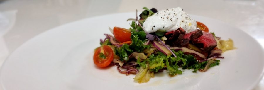 Thoroughly mixed salad with a creamy ricotta cheese on top