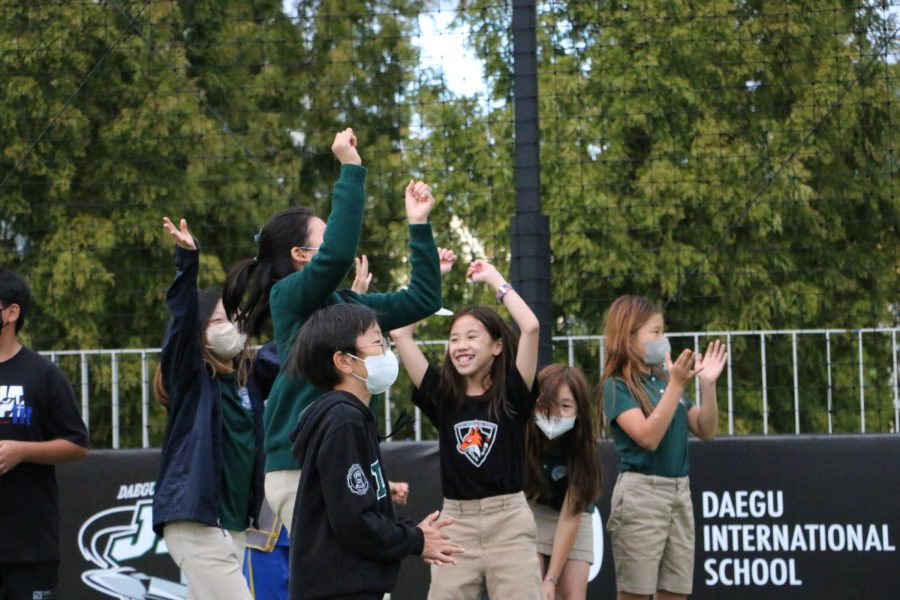5th+graders+throw+their+arms+into+the+air+for+a+victory+ceremony.+Photo+by+Raina+Lee.