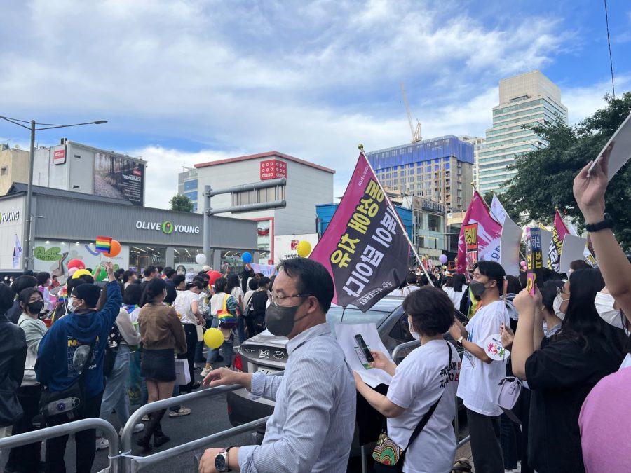The anti-queer protesters hold their placards on the sidelines as the pride parade marches by, one of which roughly translates to, Conversion is the answer (above). Photo by Elizabeth Ryu.