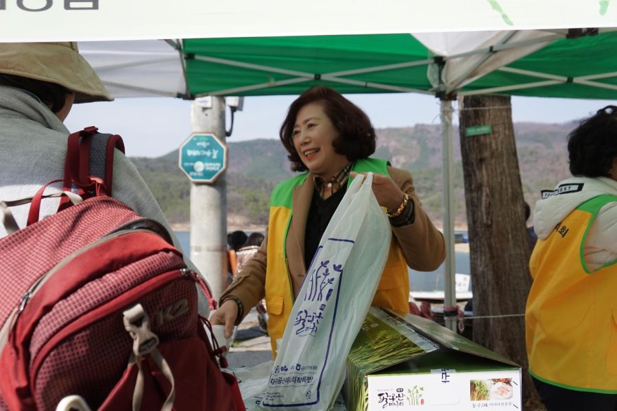 The president of the Dong-gu Council of Women interacts with walkers while selling the special Palgongsan trademarks. 