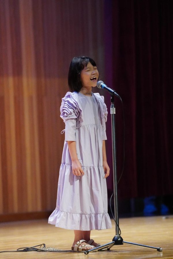 Amelia+sings+enthusiastically+on+the+stage.+Photo+by+Sean+Kim_