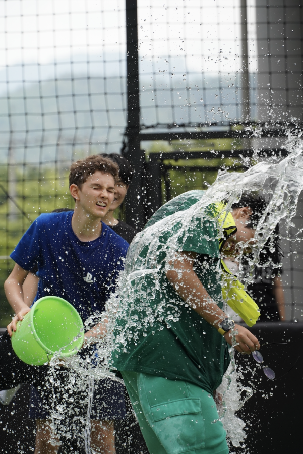 Maddox Jolly in eighth grade throws a bucket full of water onto Oliver Park in eighth grade to celebrate his win in the splashy game. Park shakes the water out of his ears and laughs it off with good sportsmanship. 
