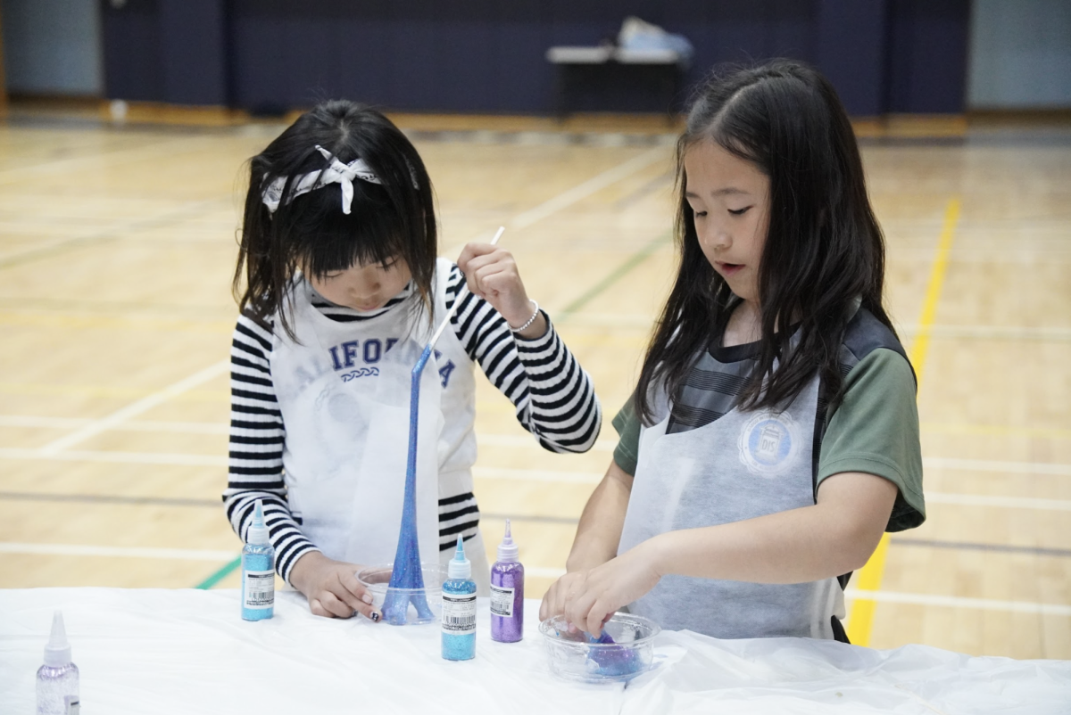 Hailie Han and Jenny Lee in third grade test out the density of their slimes, engaged in the sparkly alchemy. 