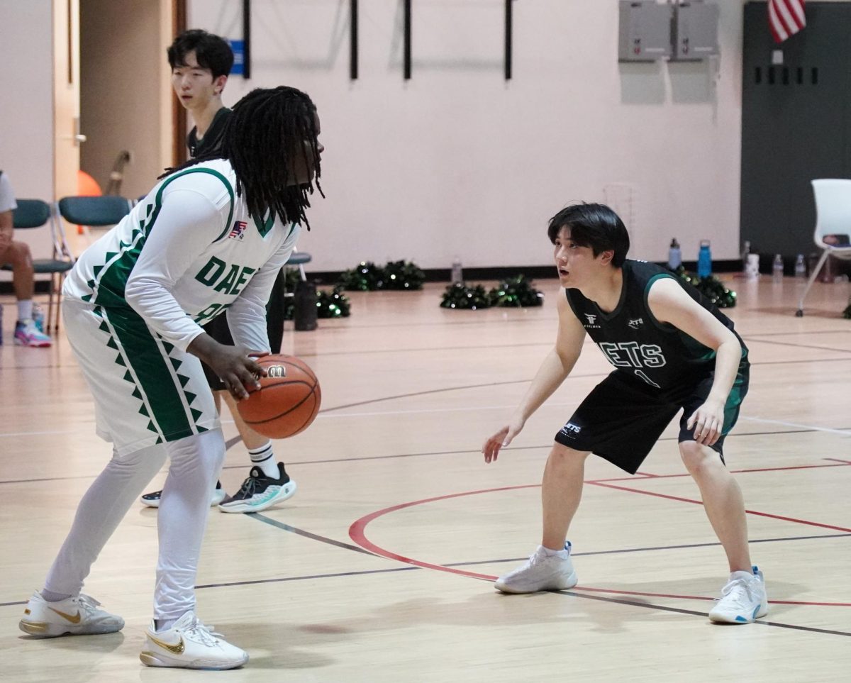 Dylan Wang (number 1), team captain, squares up in a defensive stance to shut down any driving opportunities. He gets low and balances to react to his opponents move. 