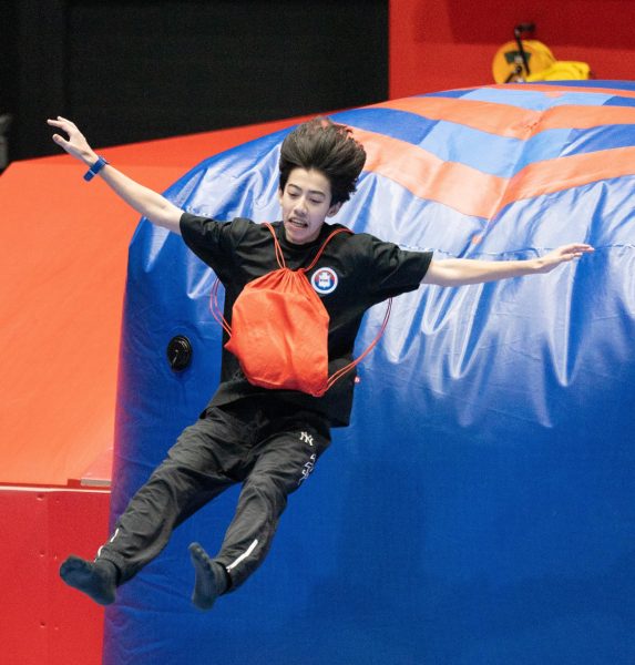 Freshman Evan Rossmeisl flies across the trampoline. His face clearly shows his excitement as he jumps down the slide. 