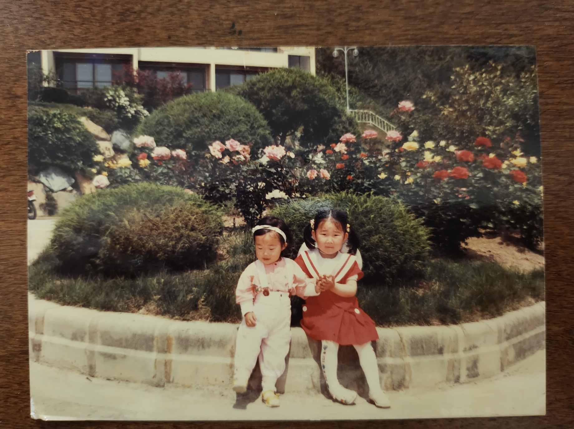 Mrs. Je (left) and her older sister (right), snap a picture in front of their fathers workplace. Nostalgia hits as Mrs. Je reminisces her time when she lived in Geoje. Photo courtesy of Mrs. Je.