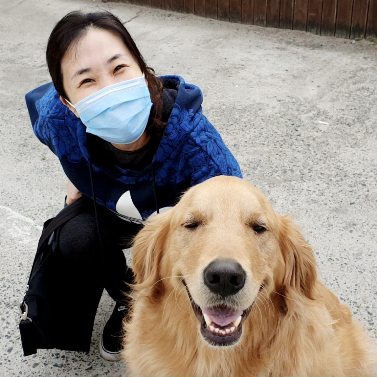 Mrs. Je squats down to take a photo with her favorite animal – a golden retriever. She met the dog in front of a Gukbap restaurant. Photo courtesy of Mrs. Je.