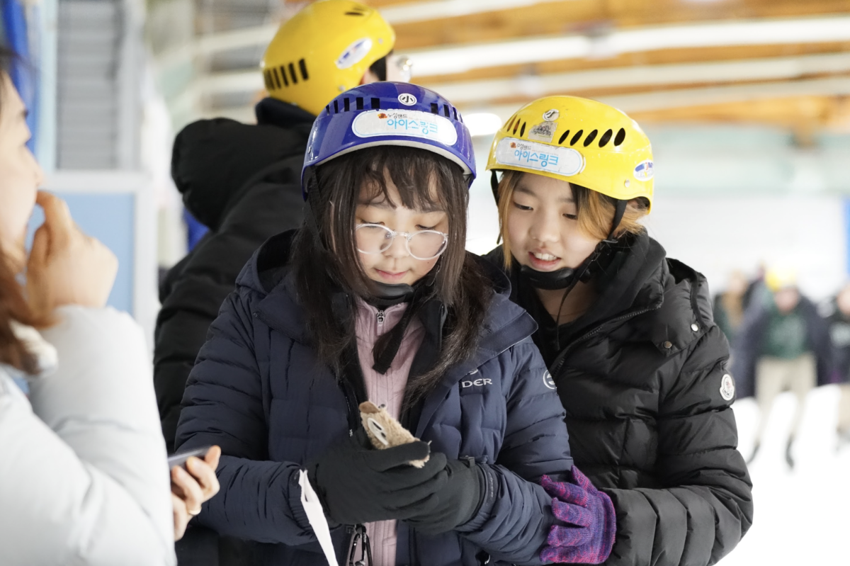 Sixth graders Olivia Cho and Esther Choi hold each other closely as they brave the chilly air of the skating rink. They find warmth in their friendship. Photo by Jessica Woo.