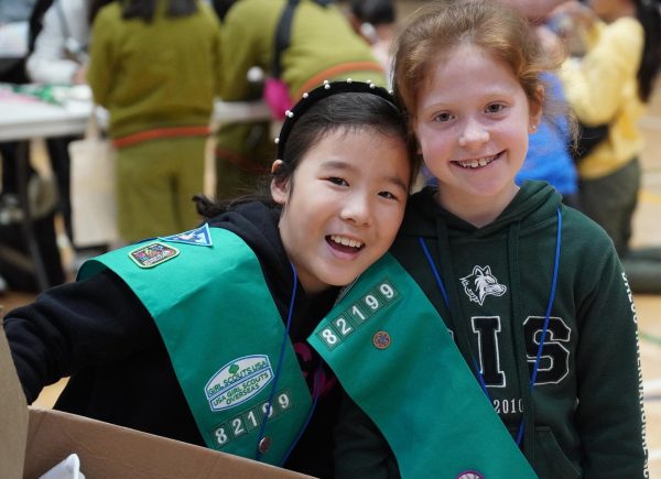 Ellie Joe and Louise Marechal in third grade can’t help but gleam during the Activity Stations. They love their Girl Scout sashes. Photo by Flora Chung.