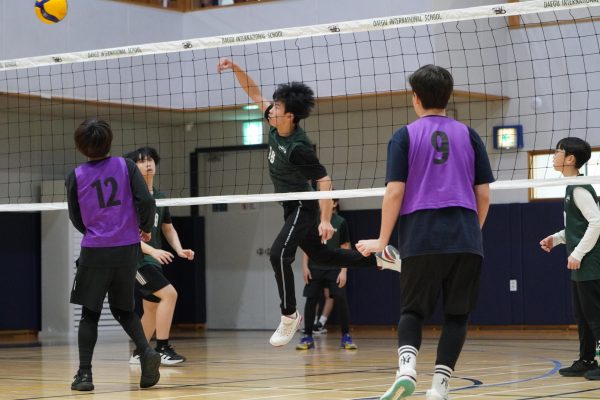 William Seo (number 16) smashes down his middle spike to the opposite court. With his quick speed, William strikes the ball with force, leaving his opponent speechless after the hit.