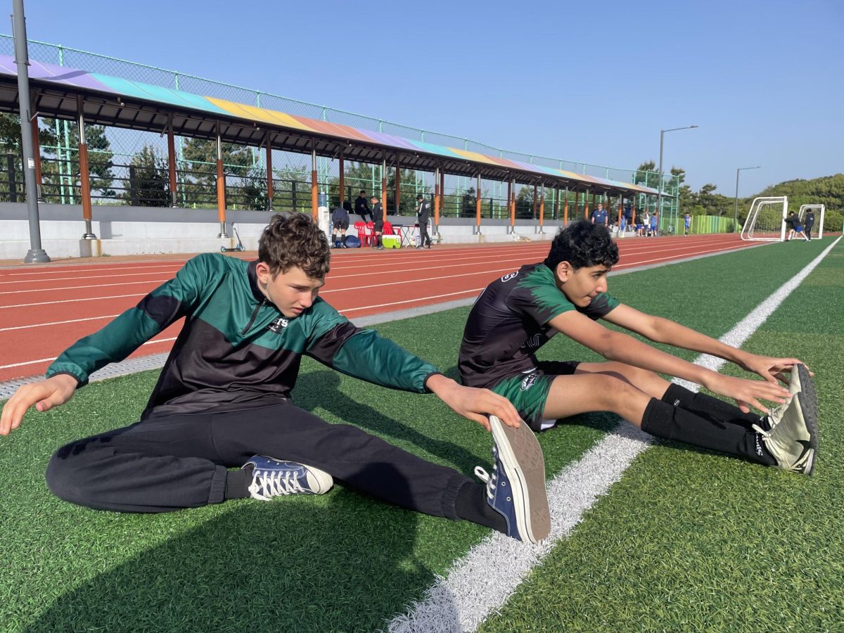 Maddox Jolly and Ali Karam stretch thoroughly before the impending game. Since the boys battled for two whole days, stretching proved to be essential.