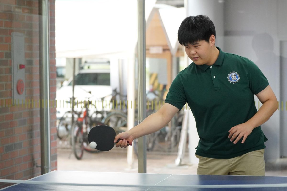 Brian Hyun in 11th grade receives the ping-pong ball from Brian Cho. He aims for the next point to take the game home. Photo by Sophia Bae.