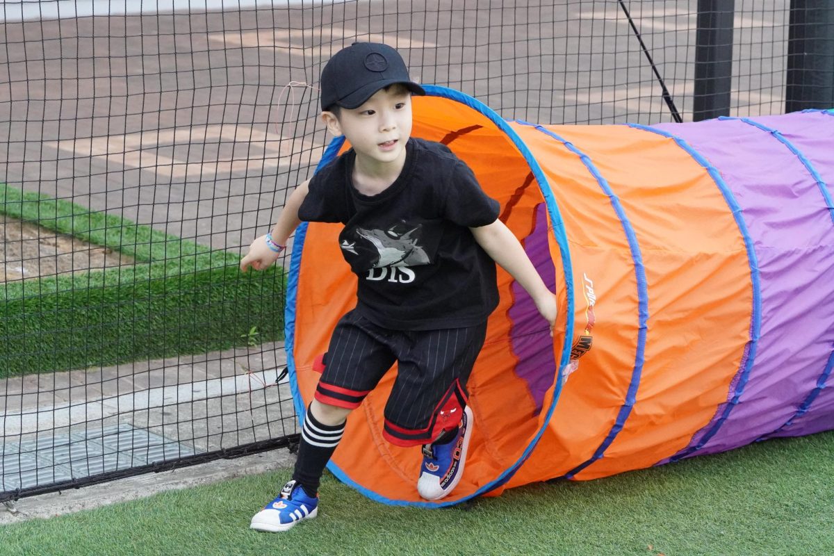 Curtis Jang in kindergarten leaps out of a fluorescent play tunnel. He scans his surroundings, ready for his next obstacle. Photo by Luna Kang.