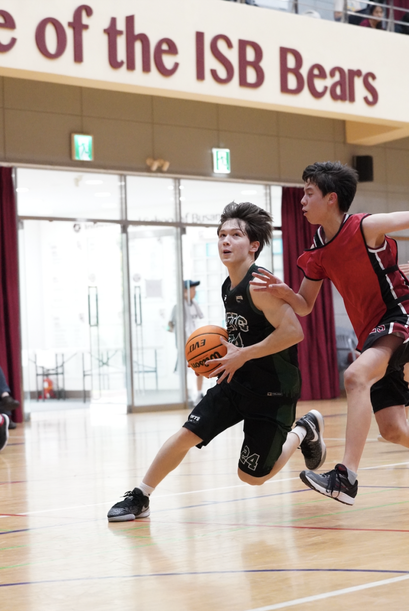 Star player Jacob McAteer drives for another chance at making a basket. His strength, built through hours of weight lifting and Coach K's exercise regimen, smoothly fends off the defense. 