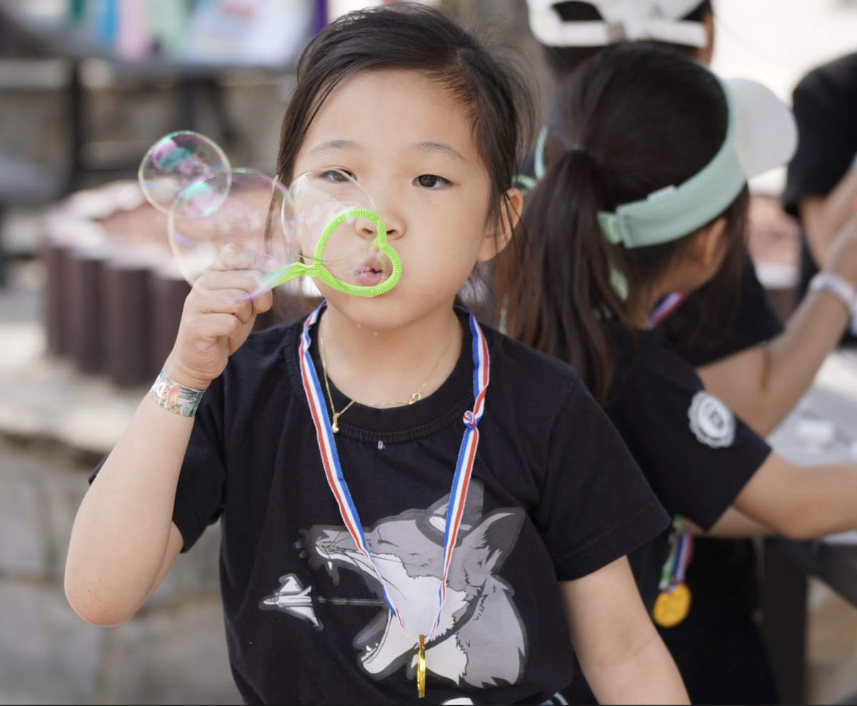 First-grader Amber Kim puffs out mickey mouse-shaped bubbles.