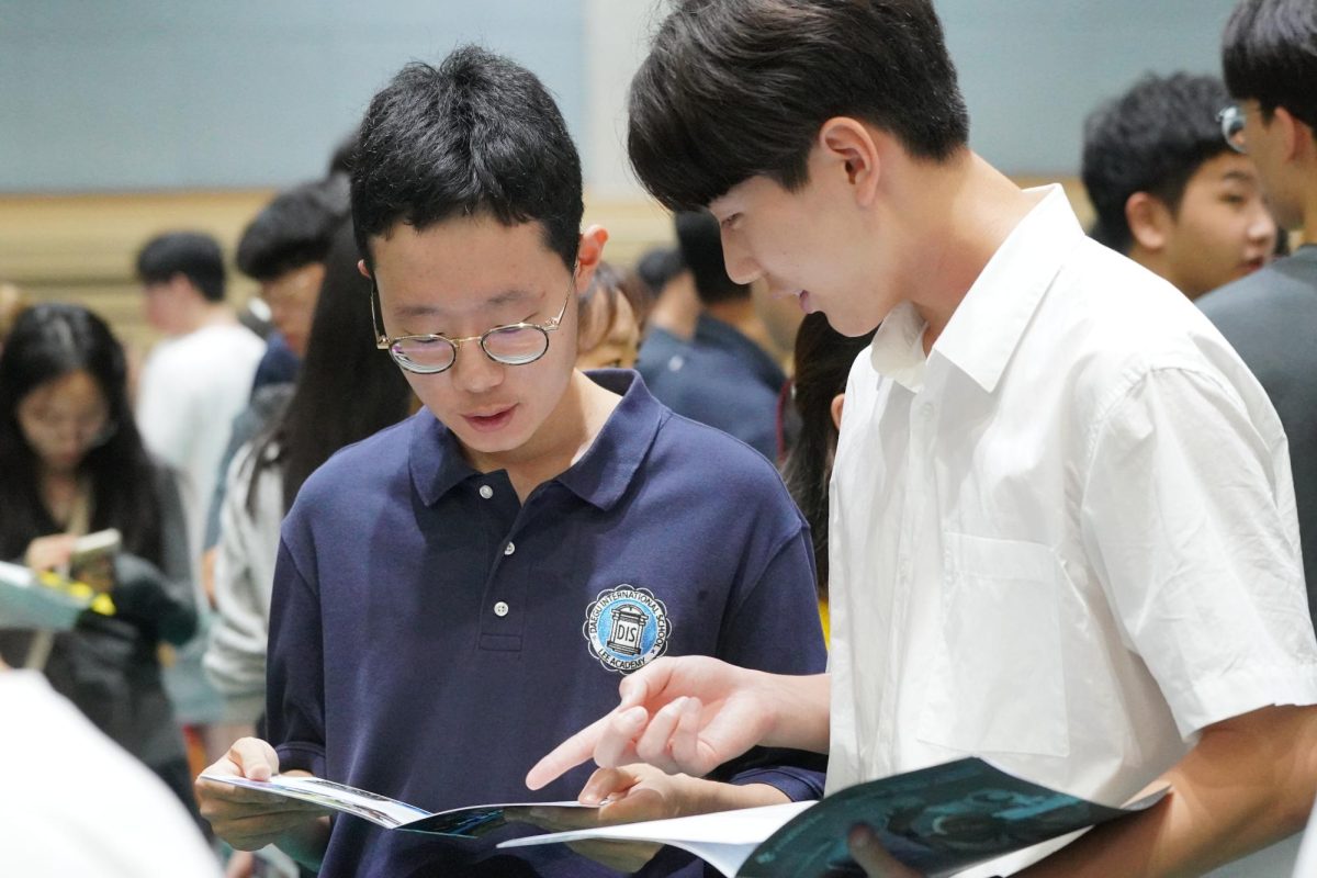 12th graders Kevin Lim and Aaron Shin look at their brochures from Washington University. Through various Q&A sessions from universities, the college search of the seniors get easier throughout the day. 