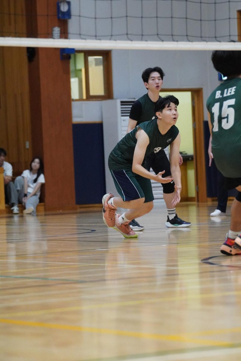 Middle blocker Sean Kim (number 28) watches the serve drop and prepares to dive immediately. His quick response to the rapid game comes from the work he puts in at practices.