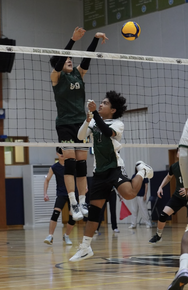  Middle blocker Colin Ji (number 99) stuffs the opponents tip. He reaches over and throws it back down to the ground. Despite the skill's difficulty, he times the block flawlessly to create a roof against hitters. 