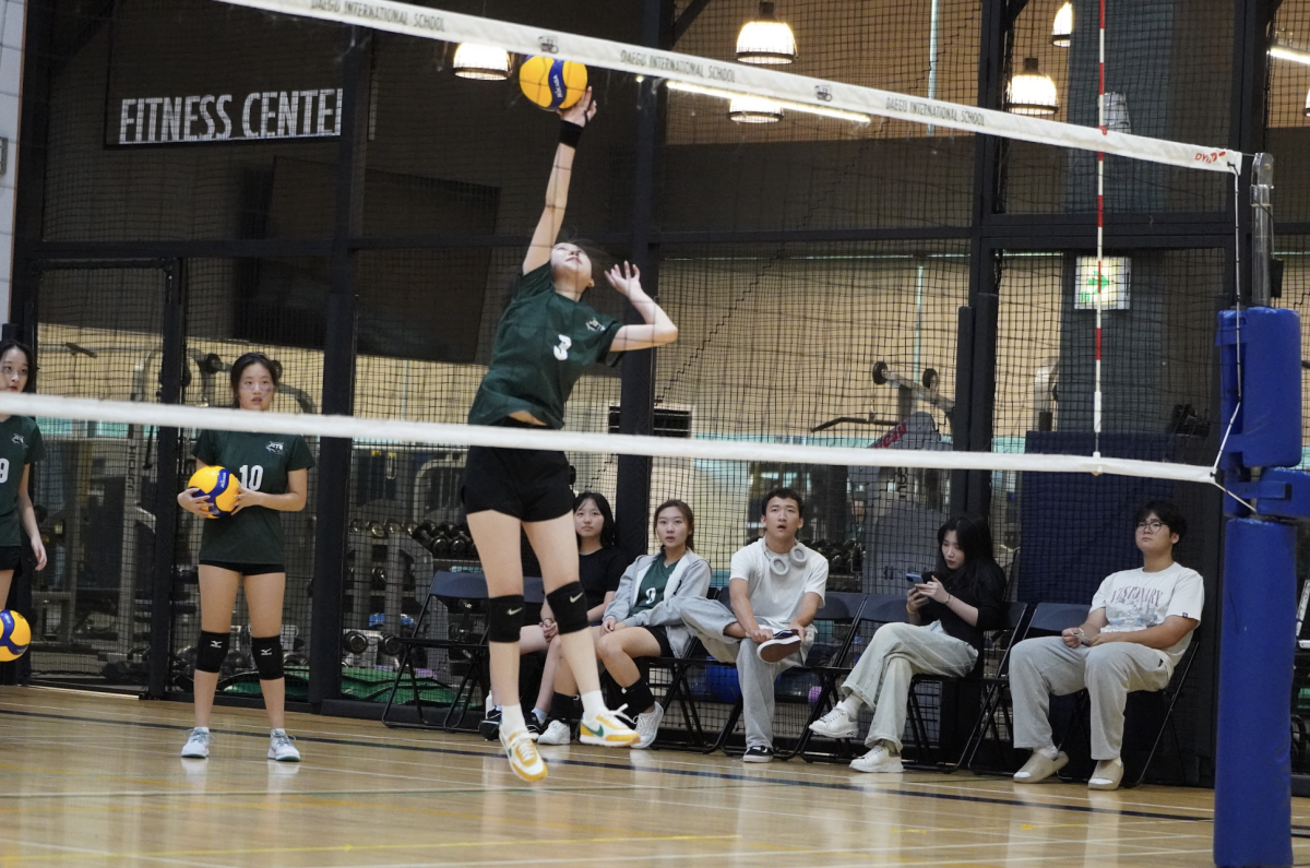 JV captain Dana Lee (3) leaps off the ground to warm up her spikes before the game. Her focus and energy set the tone for the team's pre-match preparation. 