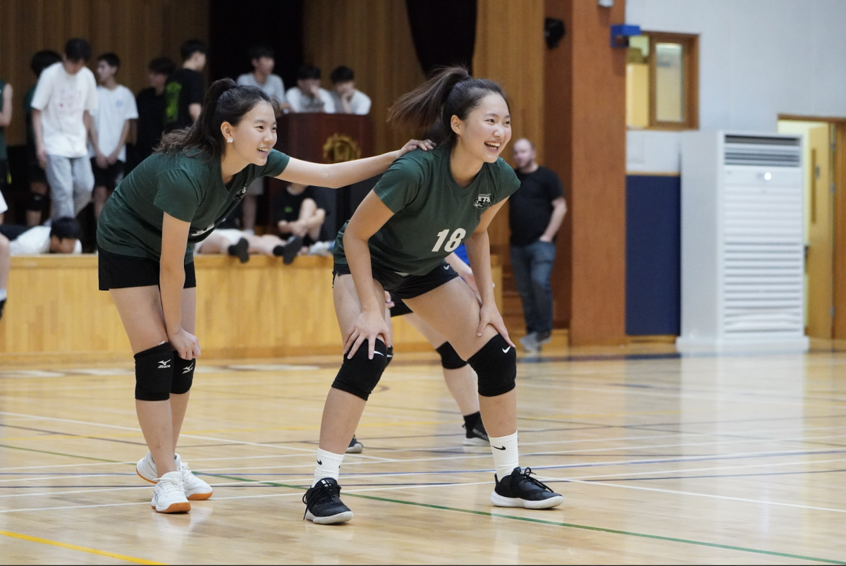 Varsity setter Leween Wang (9) pins Bonnie Kim (18) as they prepare to receive a serve. She readies up to switch positions with Bonnie to set a flawless pass. 