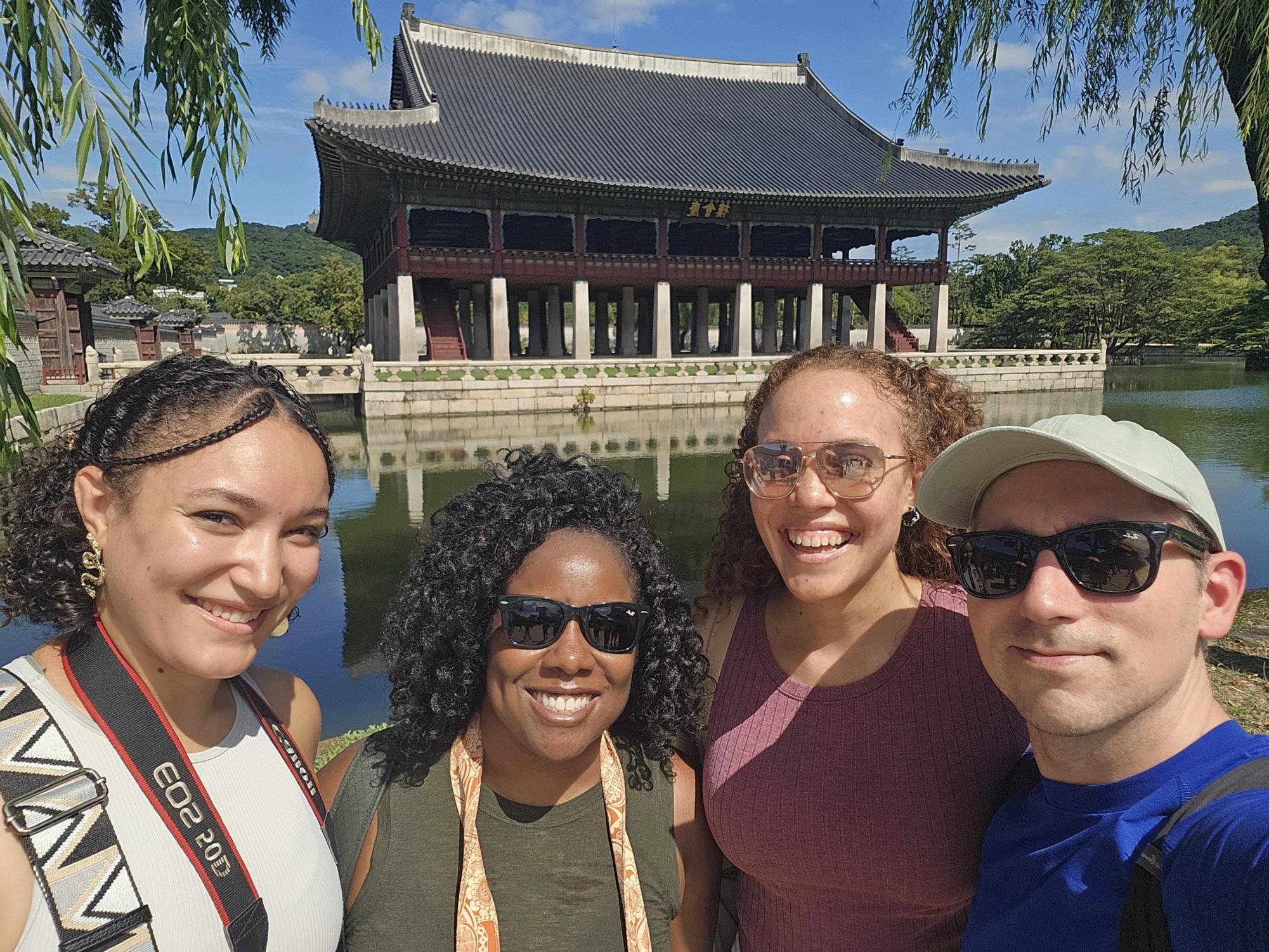 A picture is worth a thousand words; Ms. Dennard and her friends huddle around the lake in front of traditional Korean architecture. Photo courtesy of Ms. Dennard. 