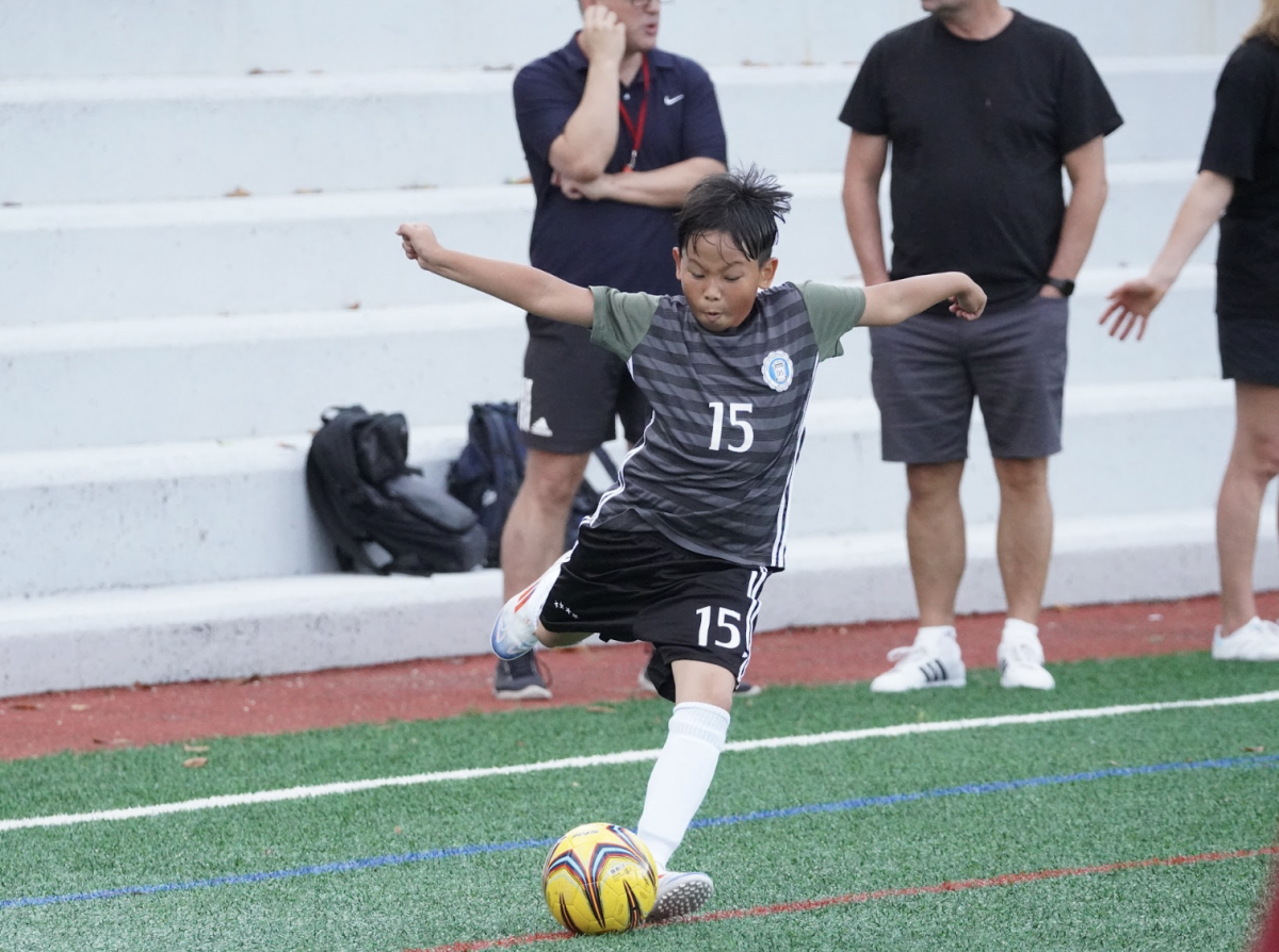 Ryan Kung in fourth grade raises his arms like a hawk about to take flight as he musters up the strength to launch the ball to his teammates.