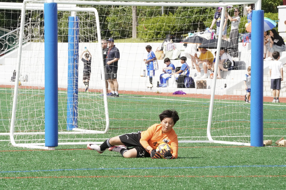 Ryan Bae in fourth grade fearlessly dives to the ground. He makes an impressive save, and the crowds cheer in awe.