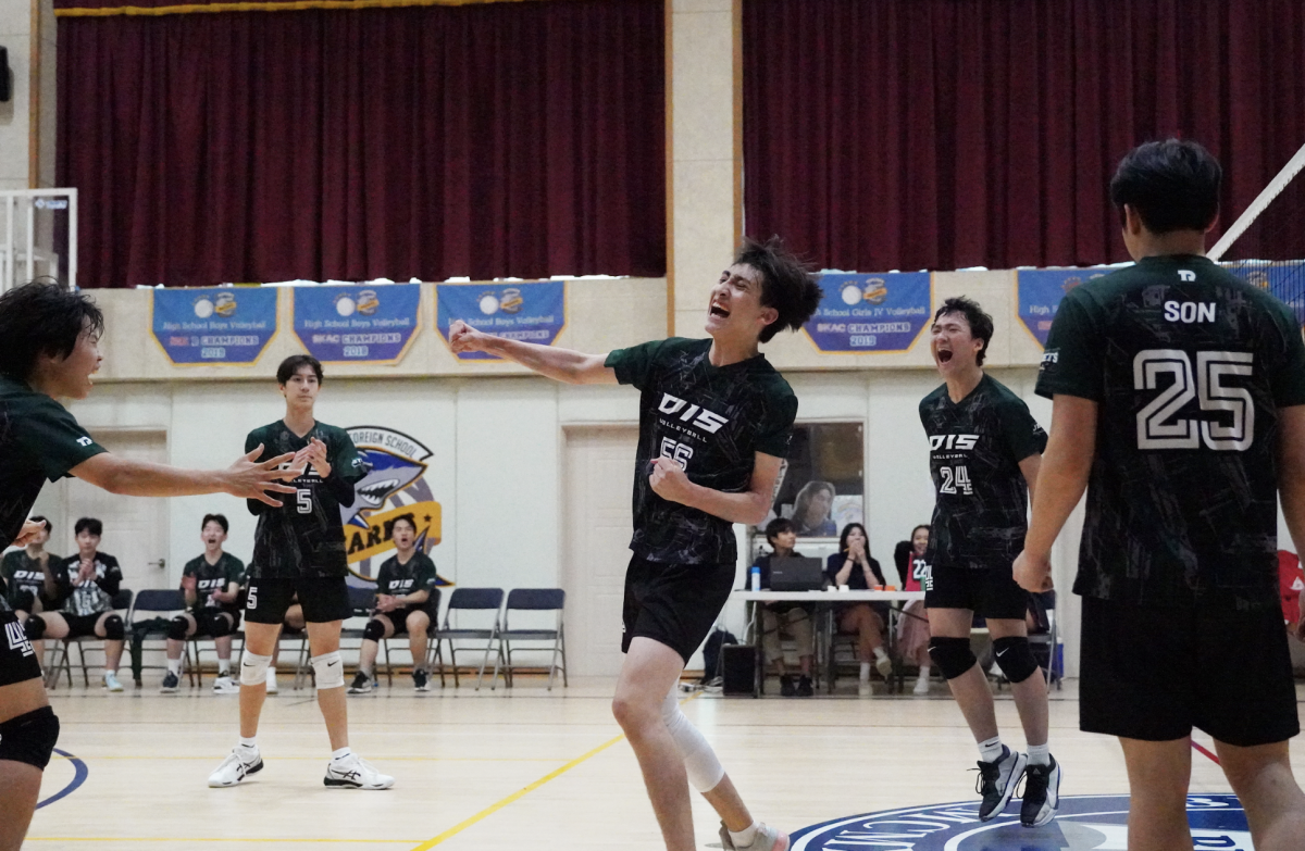 Haydn Mangione (number 56) pumps his fist in triumph after winning the first set of the finals. His teammates claps in awe and celebrates the energy with him.