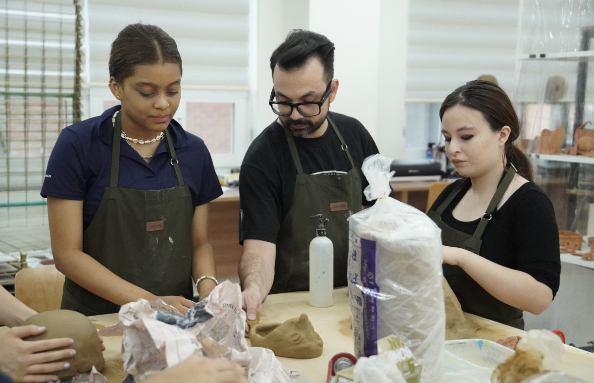 Twelfth graders Elisa Triolo and Tamara Trindade consult Mr. Gum for some advice on their independent projects. 