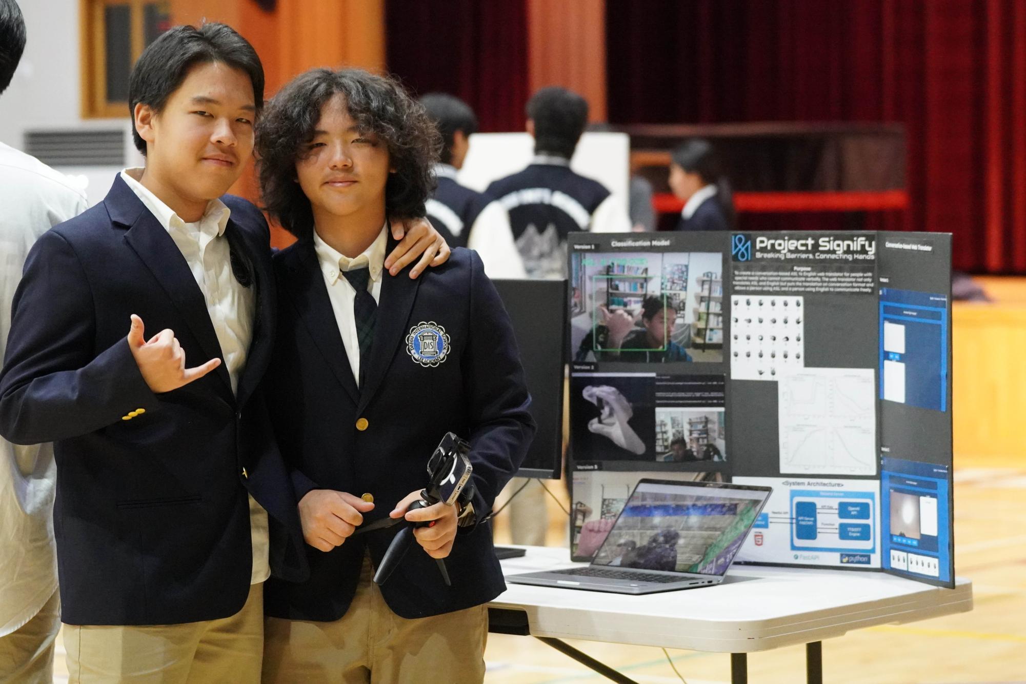 Freshman CJ Park and sophomore Yujun Piao boast their AI design, "Project Signify." Their algorithmic codes convert sign language into words and letters, surprising the audience. 