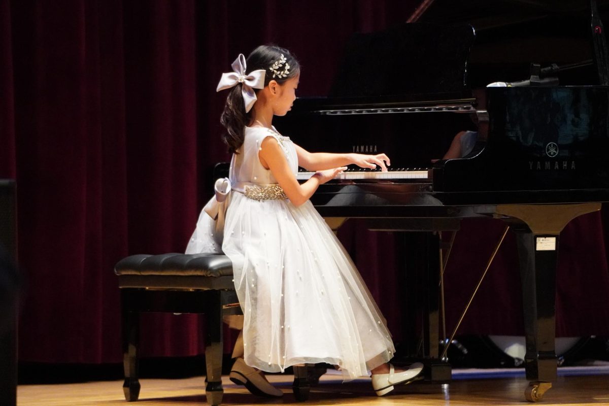 Gia Park in third grade focuses on the piano to look at the movements of her fingerings. The melodic sounds and rhythm pulses from her small hands. 