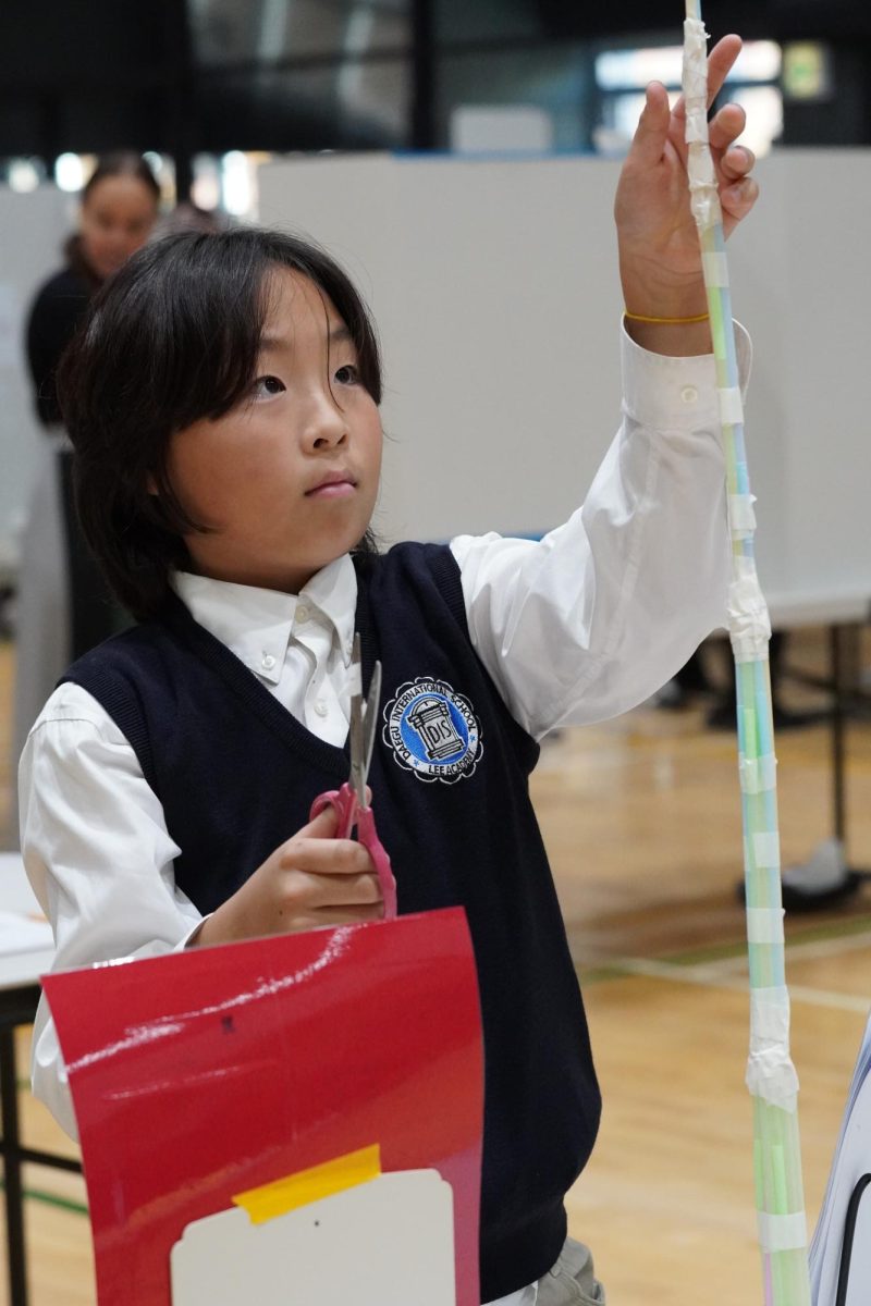  Jason Lee in third grade makes his final touches to his project before the judging. He focuses on each change, careful to not make any mistake. 