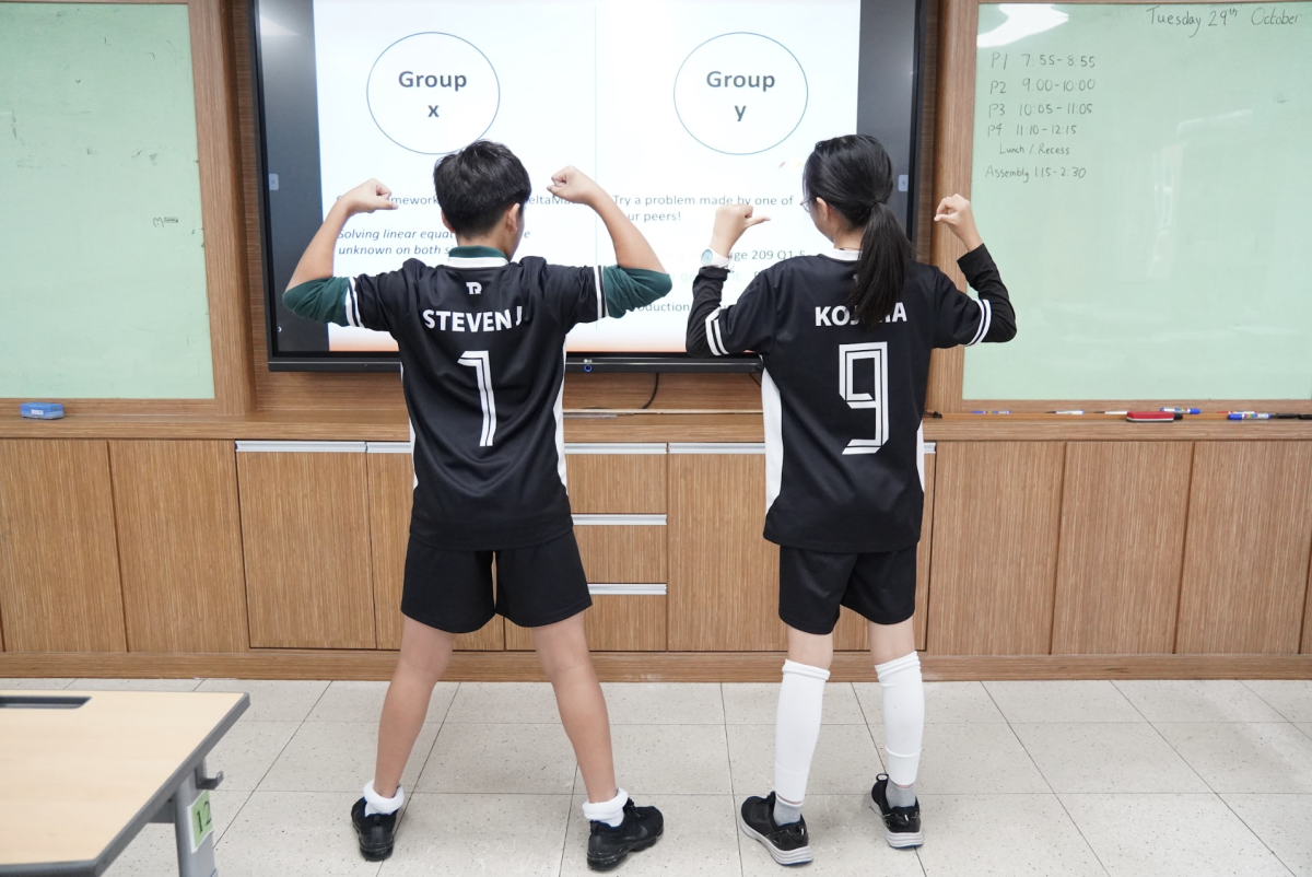 Steven Jang and Akari Kojima in sixth grade rock their customized futsal uniform for Sports Day. They love the addition of their names on the back and point at it proudly. 