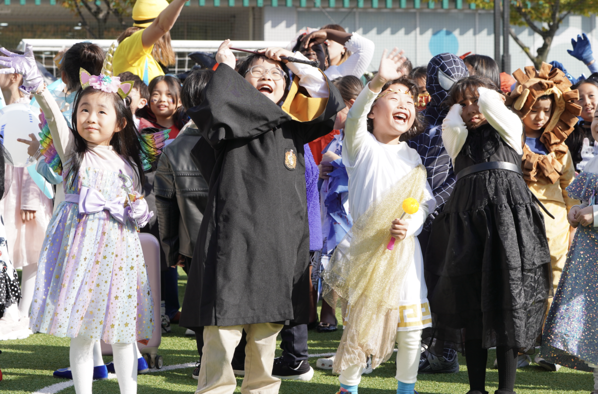 Elementary students light up the field as they smile and wave at the drone. It captures the Halloween magic in the air. 