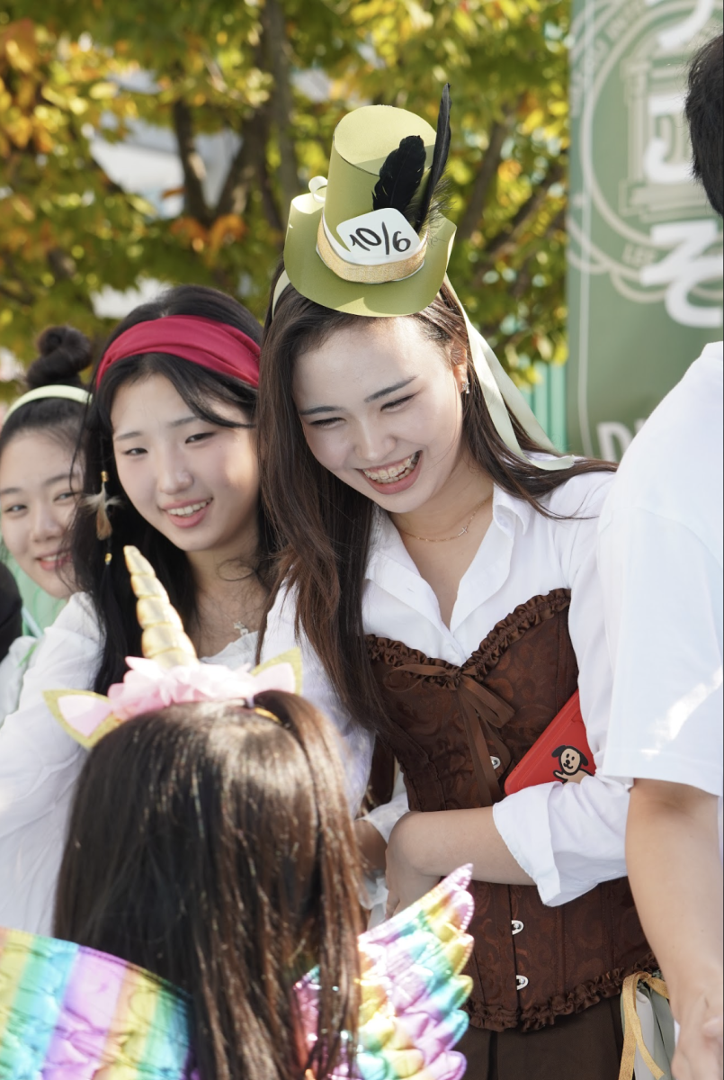 Junior Christine Mason laughs in delight as she waves at the younger kids. Elementary schoolers melt the hearts of sophomores Ginna Kim and Belle Kim. 