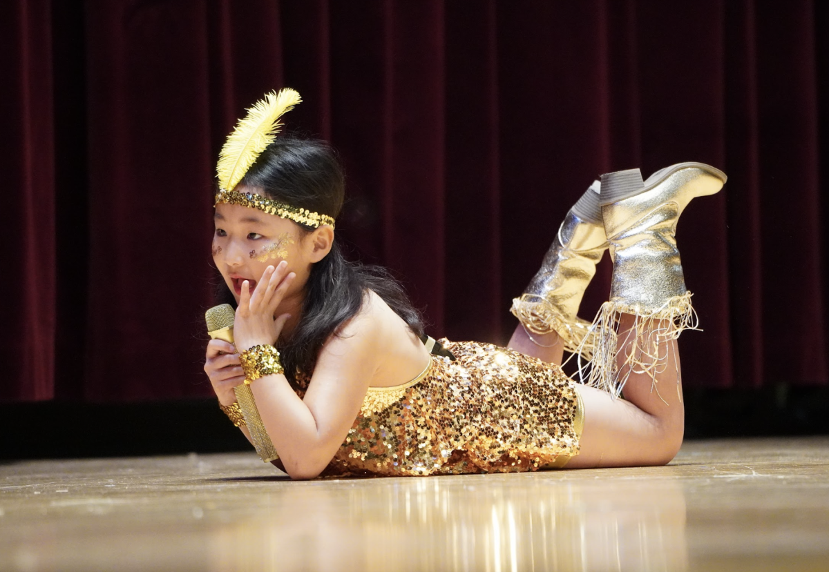 Kylie Lee in second grade lies down on the ground for the dance moves of “Shake It Off.” Alongside the detailed dance moves, her energetic vocals embody the spirit of a diva.