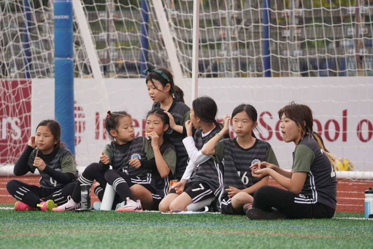 The elementary girls enjoy some downtime after their exhausting game. They nibble on snacks and carb up for their next match. 