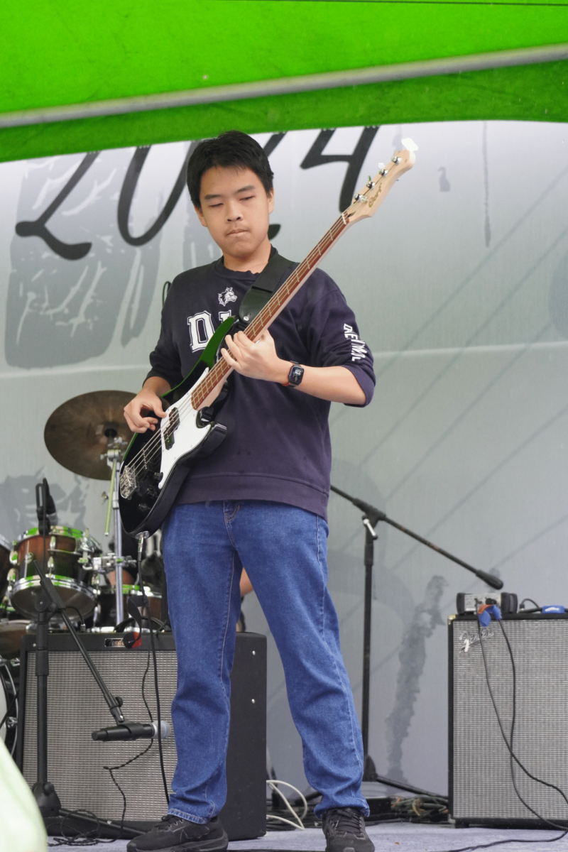  Sophomore Yujun Piao plucks his bass with precise fingering. Despite the gloomy day, the band's energizing music hypes the crowd up. 