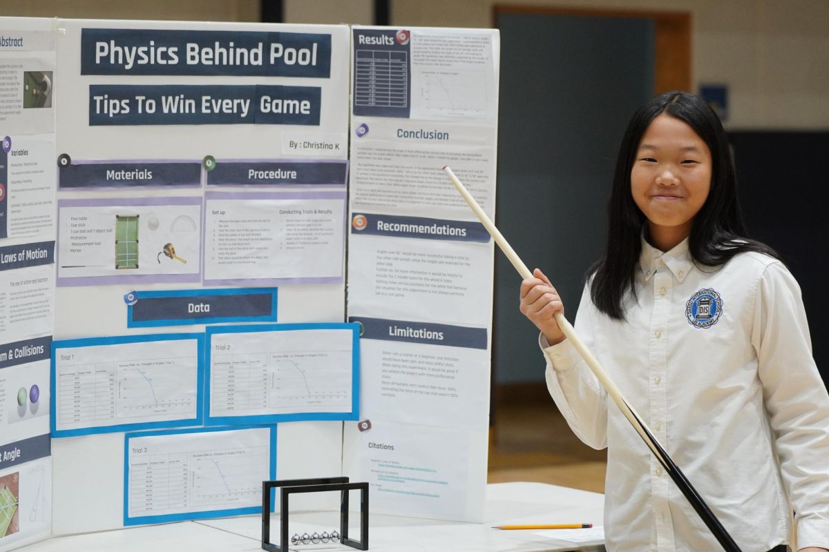 Christina Kim in 7th grade shows off her pool game physics project. Her passion for the pool game allowed her to compete at SKAIS. Photo by Lily Lee.