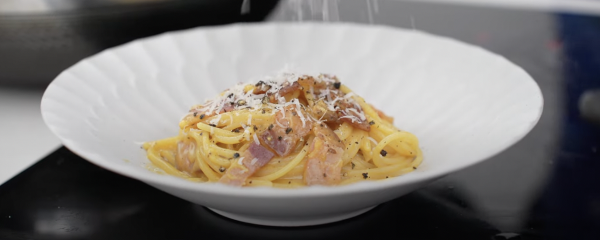 The parmesan cheese snows across the creamy carbonara.