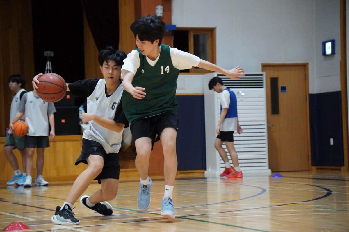 Freshman Alex Jang crosses up freshman Alex Seo during the dribbling drill. Jang attempts to make quick moves in the confined space he has to blow by his defender. 