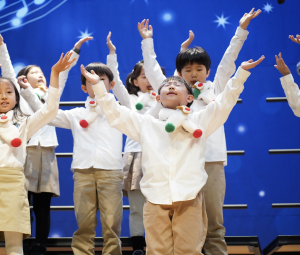 Second-grader Teddy Kim reverently receives the holiday spirit, in-tune with the musical performance. 