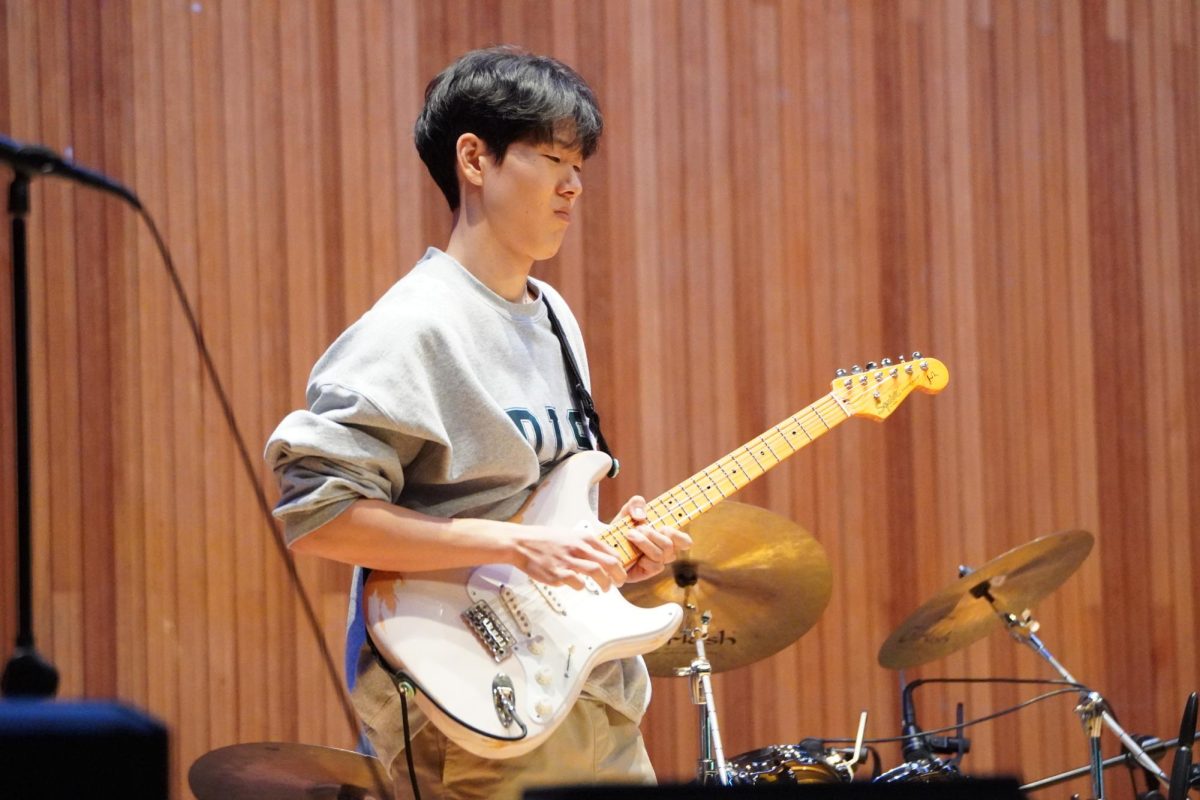 Senior Colin Ji plucks his electric guitar and hits the high notes of the song “Don’t Look Back in Anger” by Oasis. The striking notes lead the audience to chant the chorus with their peers as waves of emotions fill the air. 
