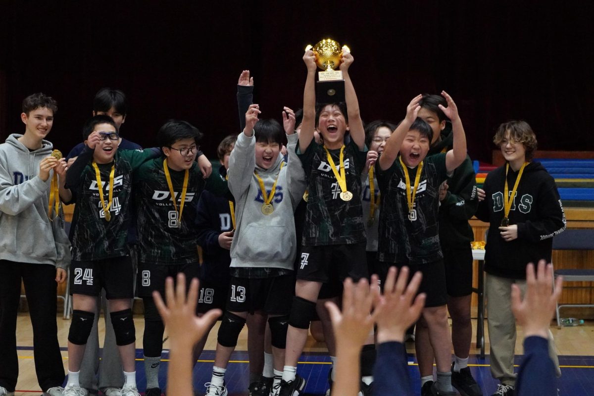 The JV squad holds the trophy in triumph at the home of the Sharks. Despite injuries and obstacles, they finish atop the podium. Student coaches Alex Seo, Maddox Jolly, and Jayden Hayward proudly celebrate their moments with the team.  
