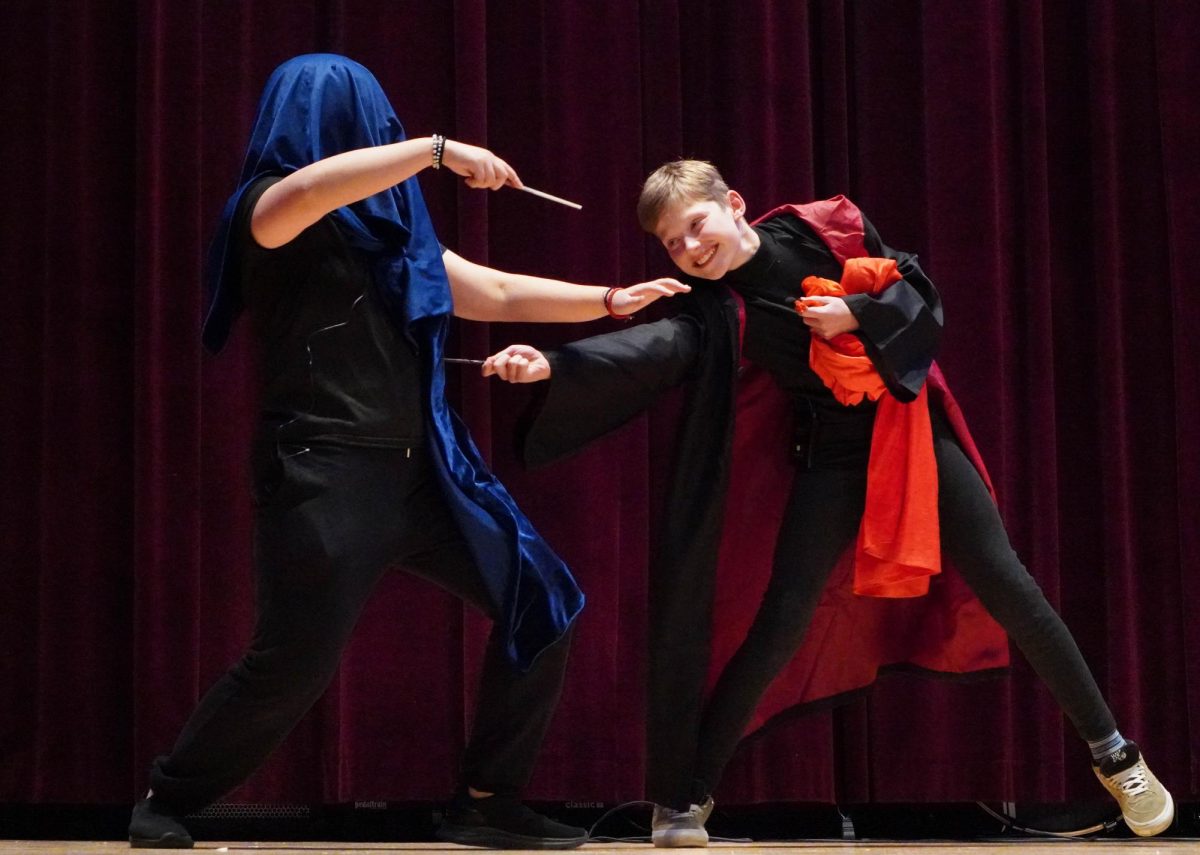 Sixth grader Paul Marechal, as Harry Potter, intently duels against eight grader Katniss Kim as Voldemort. He courageously flicks his wand and takes her out by surprise. 