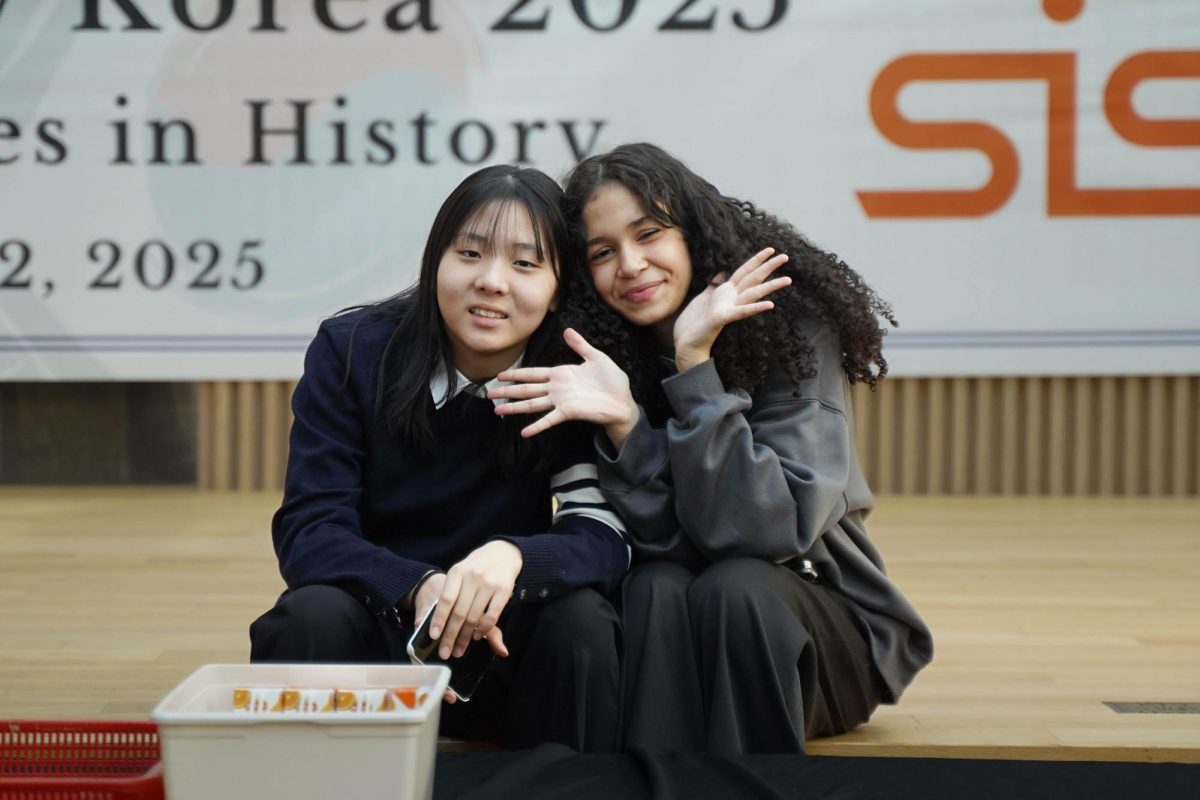 With the competition in full swing, eighth graders Bella Choi and Luisa Silva take a moment to strike a playful pose. Their smiles capture a lighthearted break amid the excitement. 