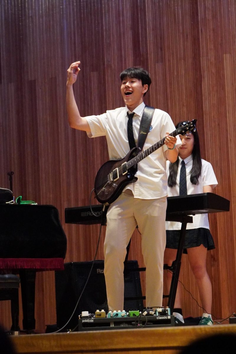 After acing his guitar solo, senior Colin Ji pumps his fist in the air. He rocks out to the music GS25 creates as the band completes their final performance.