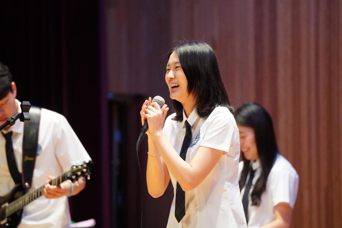 Senior Jessica Woo bursts into laughter during the interlude, soaking in the audience’s cheers as her bandmates fill the gym with ambient sound.