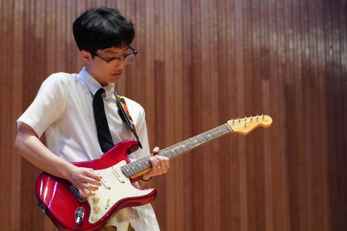 Junior Chris Ryu concentrates on his guitar solo for "Just the two of us" by Bill Withers and Grover Washington, Jr.. He meticulously shreds the guitar.