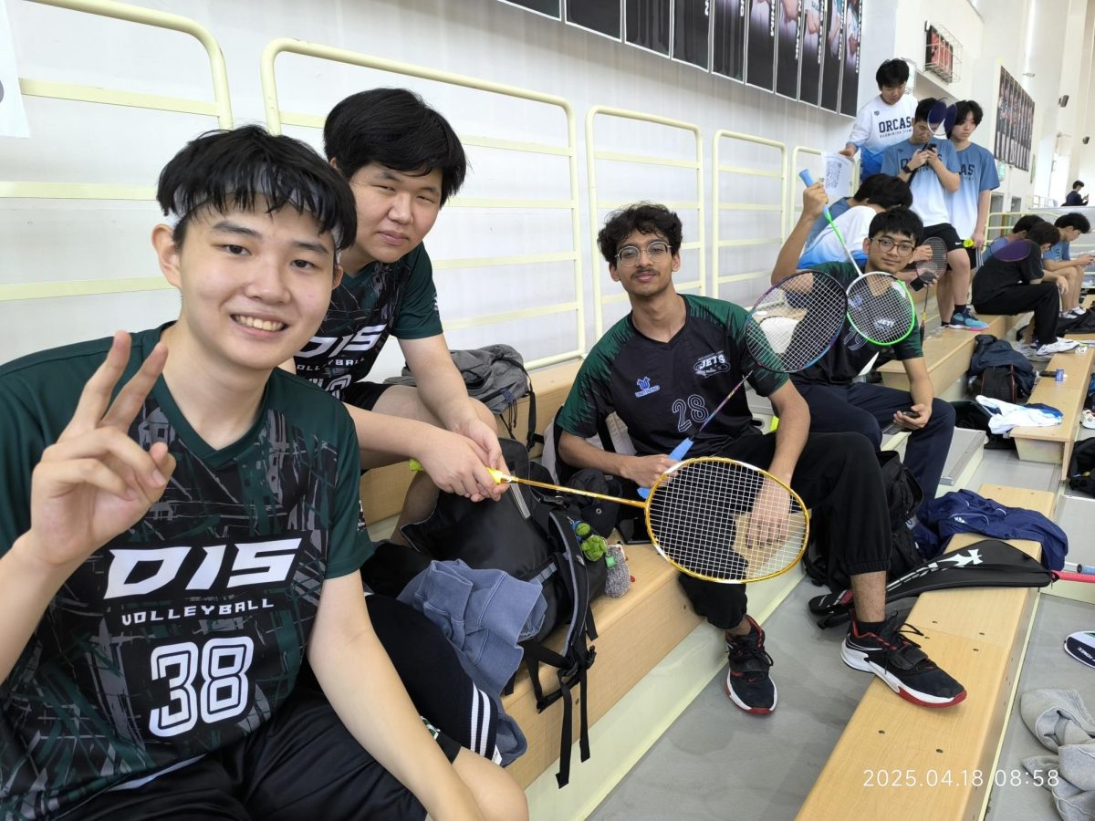 The Jets boys' badminton team celebrates their two-day tournament with their rackets up in the air. They look forward to returning next year and achieving at a higher rank. 